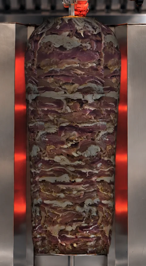 Döner ocağında, üst üste dizilmiş dilimlerle LEVANT hindi döner.